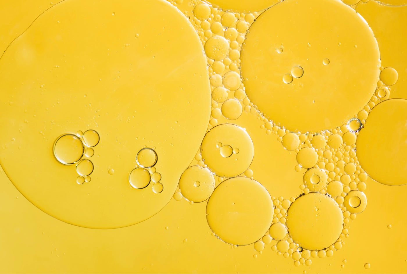 Hair Addicct close-up of rapid hair growth serum and  bubbles on a yellow background